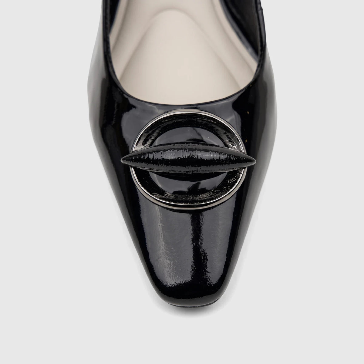 Close-up of a shiny black patent leather Capelli Rossi slingback block heel court shoe with a decorative buckle.
