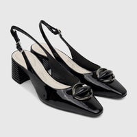 A pair of black patent leather Capelli Rossi slingback block heel court shoes with decorative metallic hardware and stacked