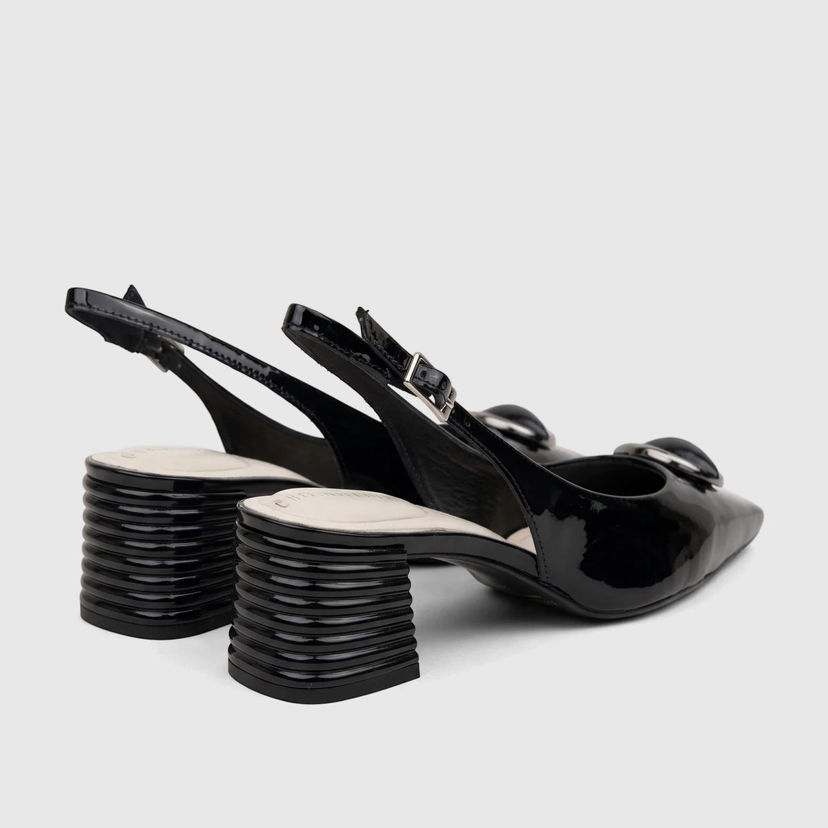 Pair of Capelli Rossi black patent leather ladies slingback block heel court shoes with silver buckles.