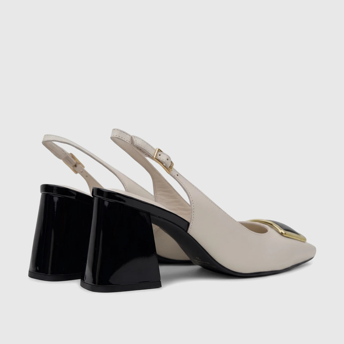 A pair of Capelli Rossi bone leather slingback block heel court shoes with glossy black heels and gold hardware.