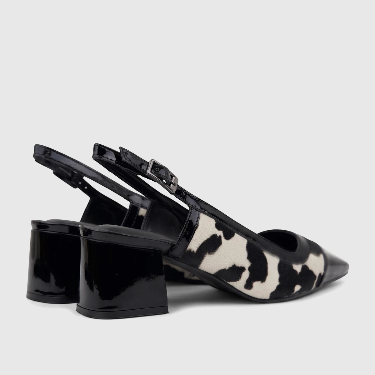 Capelli Rossi black and white cow print leather slingback block heel court shoes with patent leather accents.