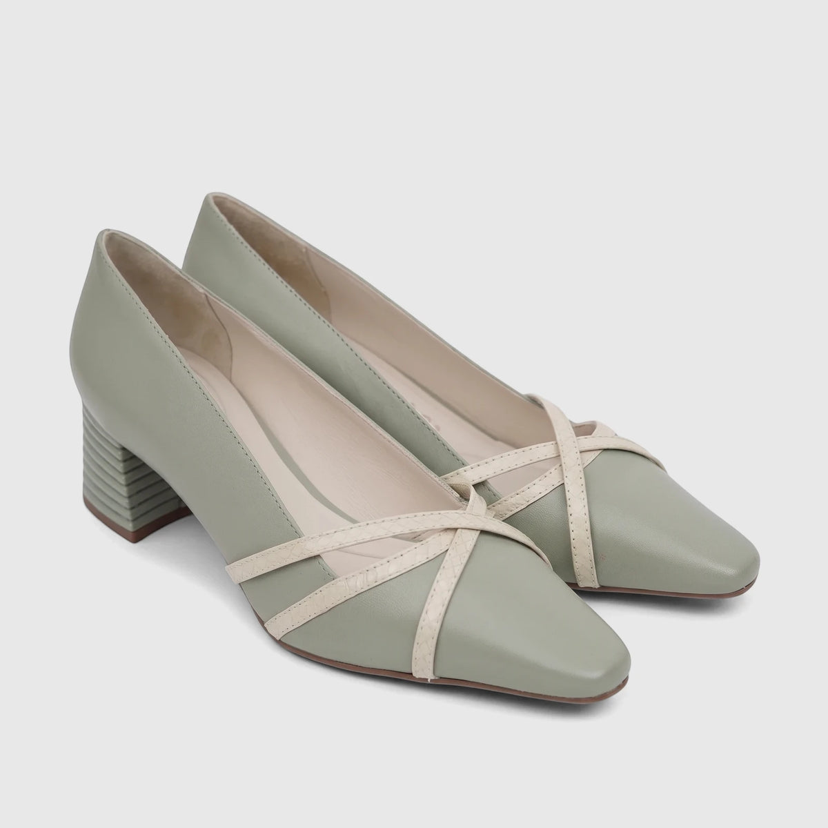 Pair of Capelli Rossi green leather block heel court shoes with a square toe and criss-cross straps, viewed from an angle.