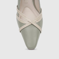 Close-up of a green leather ladies' court shoe with cream criss-cross straps and a pointed toe.