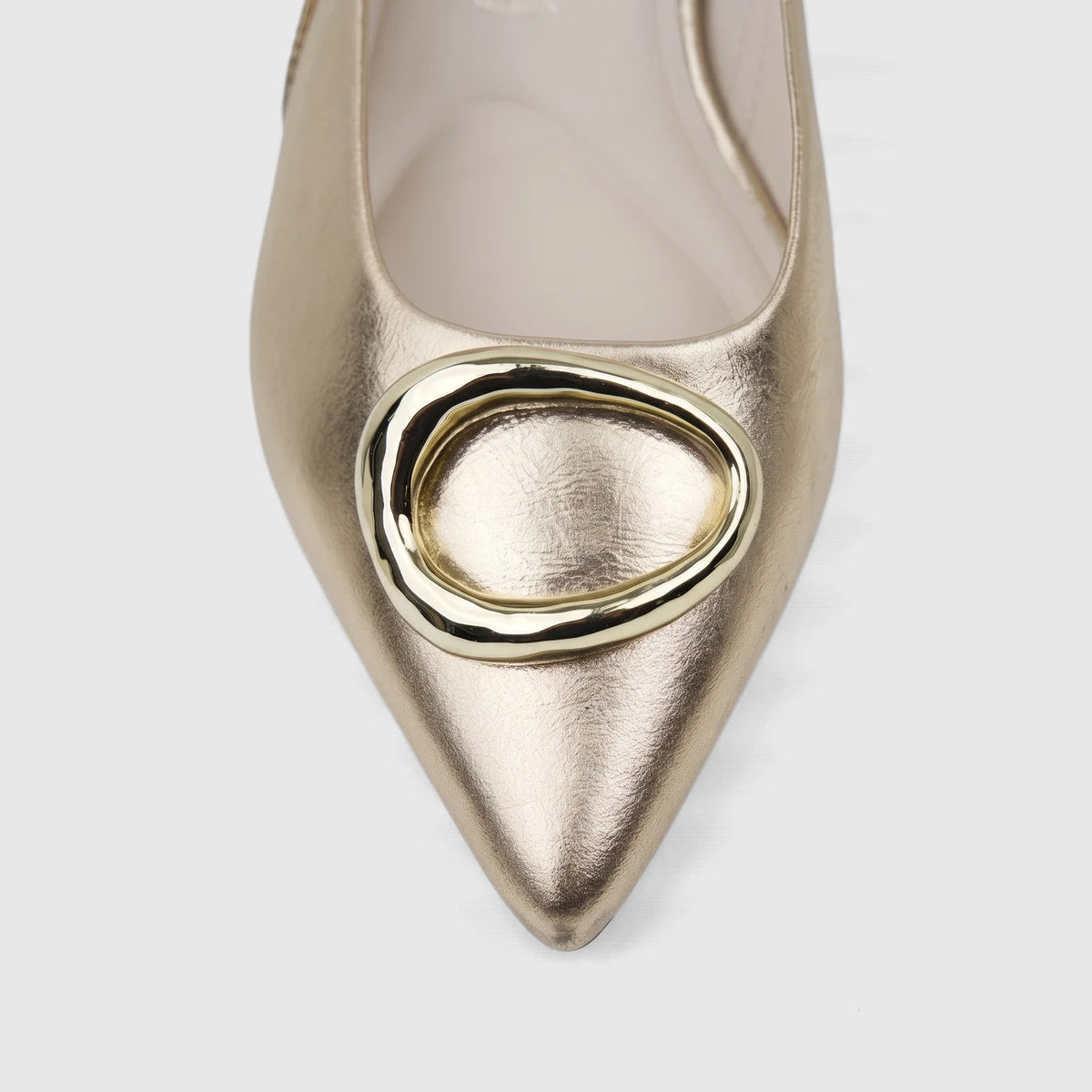 Light gold Capelli Rossi leather ladies pump with a pointed toe and an oval gold buckle detail.
