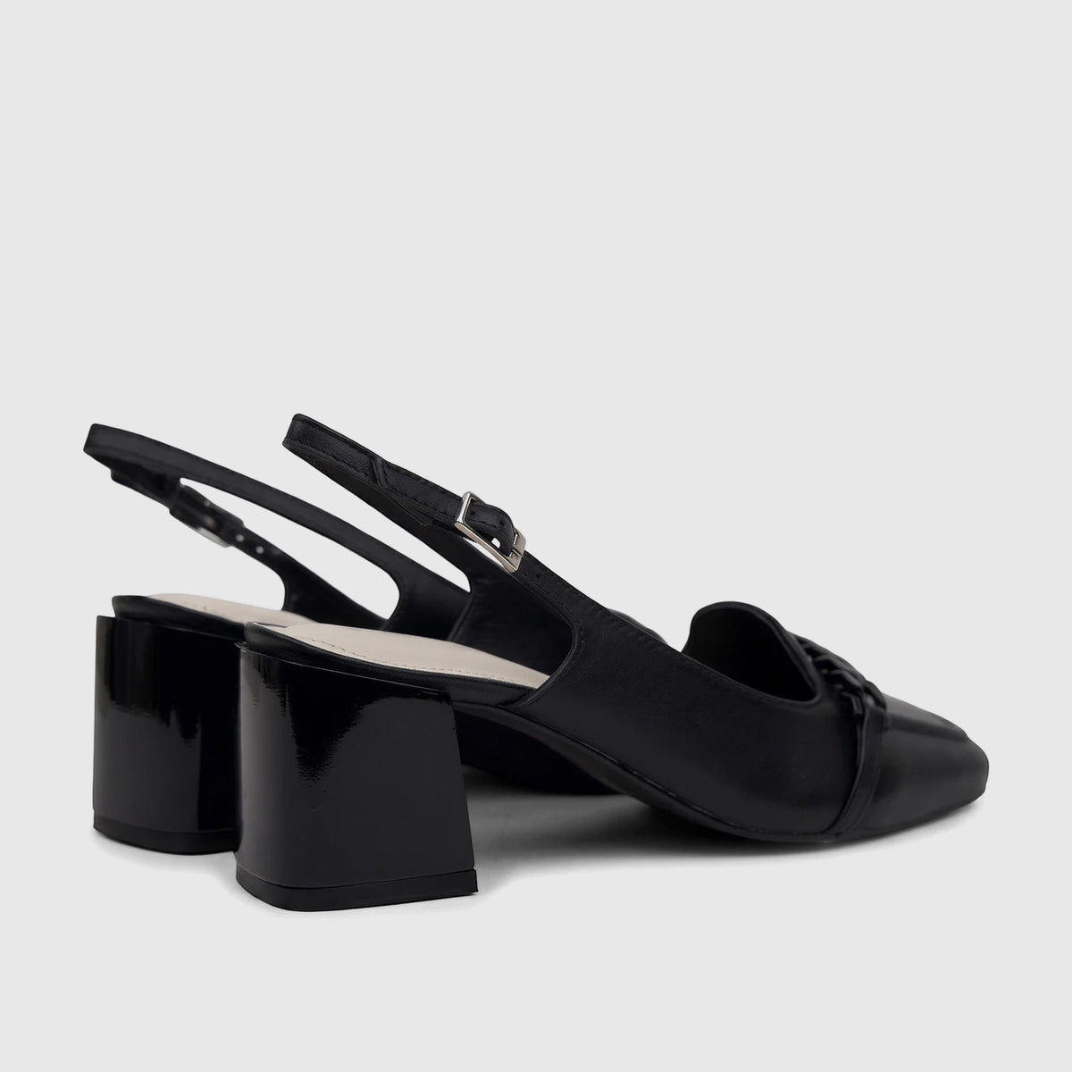 Black leather Capelli Rossi slingback block heel court shoes with a braided vamp and silver buckle, shown from a side angle.