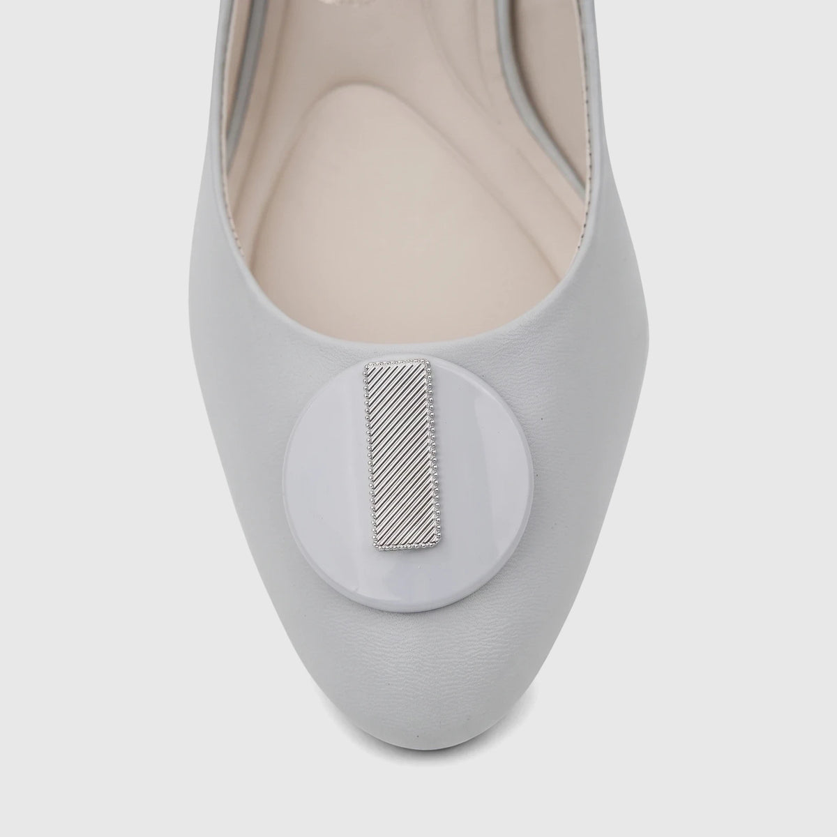 Close-up of a Capelli Rossi powder blue leather slingback court shoe, featuring a circular toe embellishment with a striped