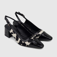 Two black and white cow print Capelli Rossi slingback block heel court shoes made of leather and cow hair.
