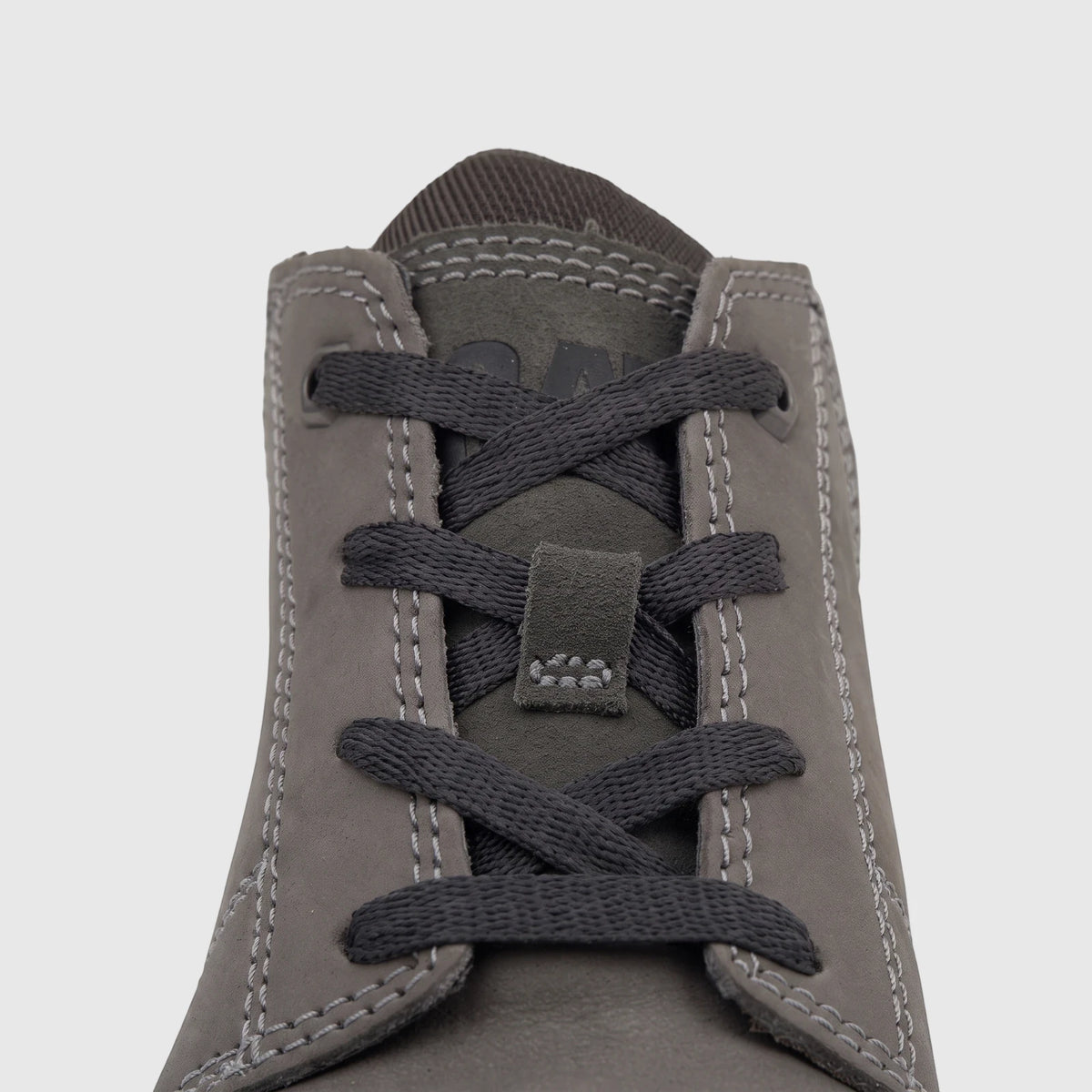 Close-up of a gray Cat Men's Threshold Chukka boot, featuring intricate dark lacing and visible white stitching.