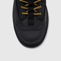 Front close-up of a black Cat Men's Colorado Expedition Hiker boot, featuring yellow and black striped laces and a textured