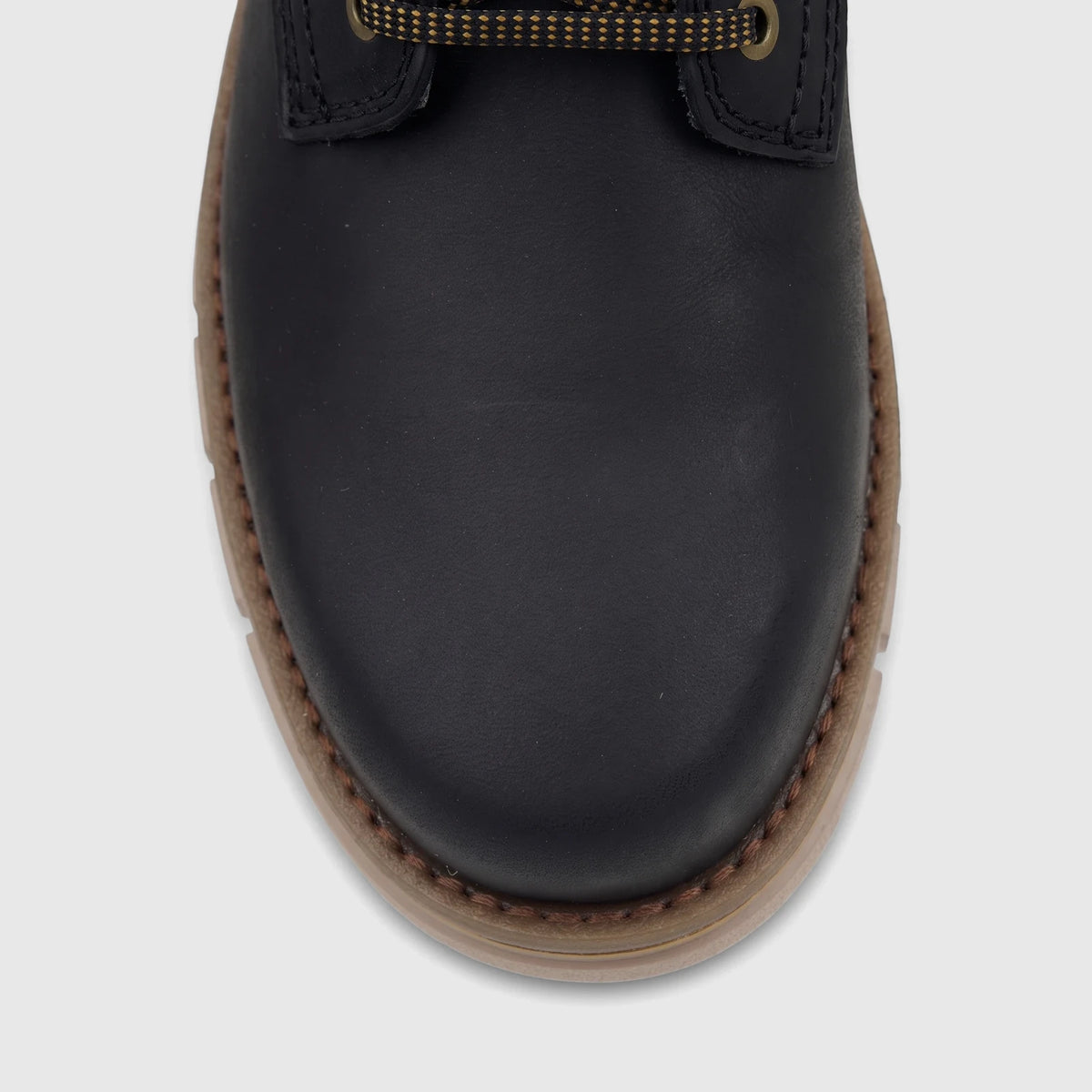 Close-up of a Cat Men's Estimate black chukka boot with a brown sole and yellow patterned laces.