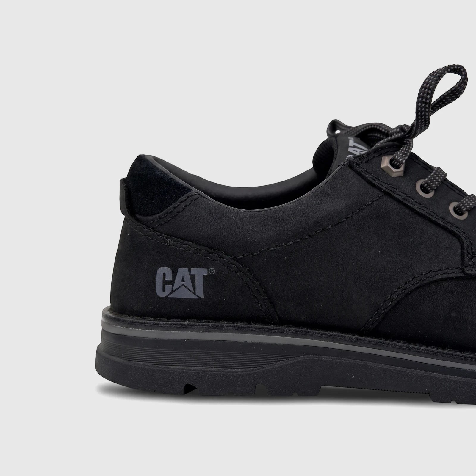 Side view of a black Cat Men's Estimate Lo P727005 shoe, featuring a durable design with textured black material and branded