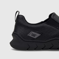 Close-up side view of a black Cat Men's Flexion Slip On shoe, made of textured leather with a distinctive pattern on the