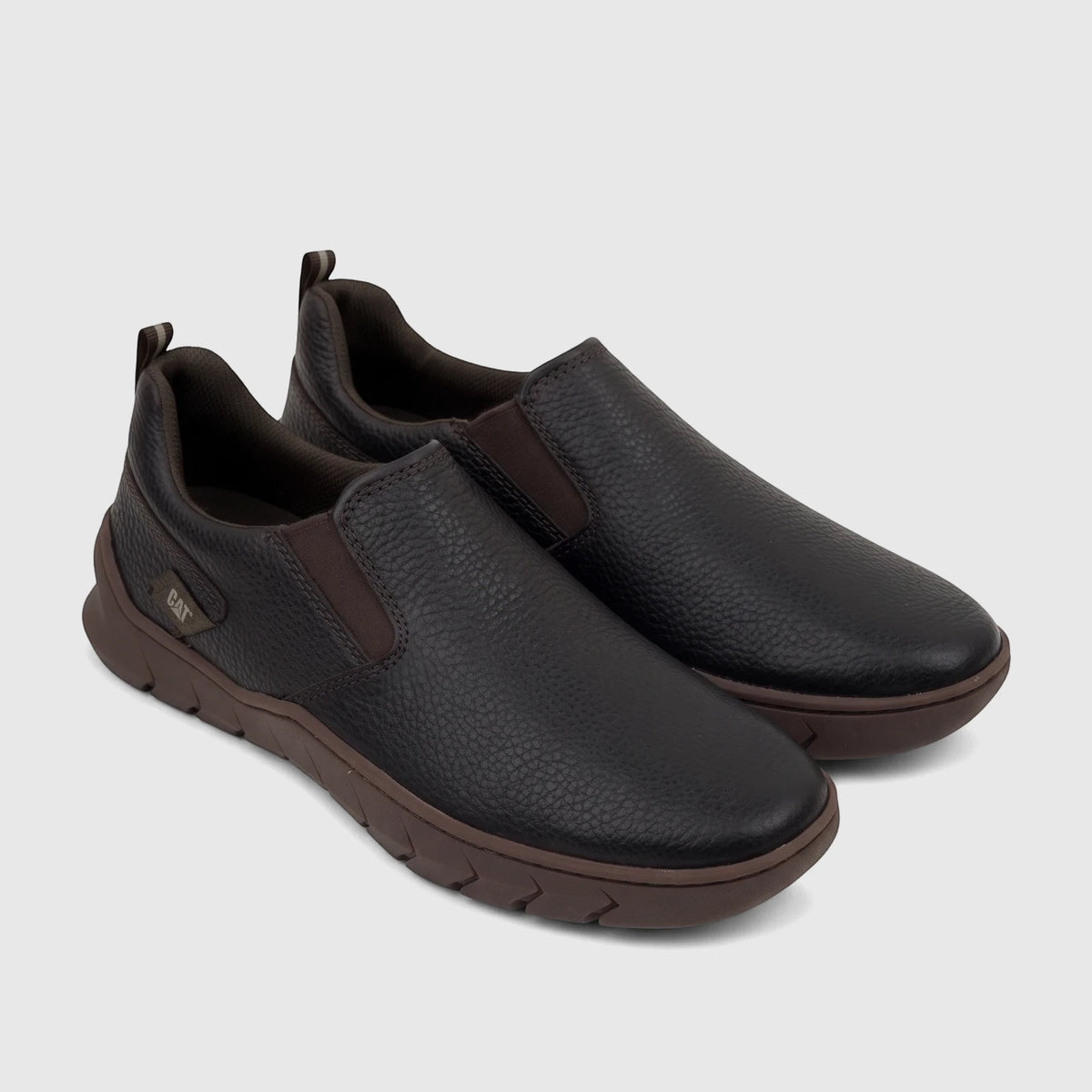 Pair of dark brown textured leather Cat Men's Flexion Slip On shoes with lighter brown soles, displayed from a slightly