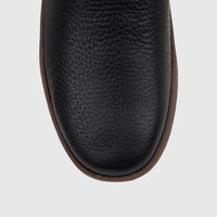 Close-up top view of a black pebbled leather Cat Men's Flexion Slip On shoe with a contrasting brown sole.
