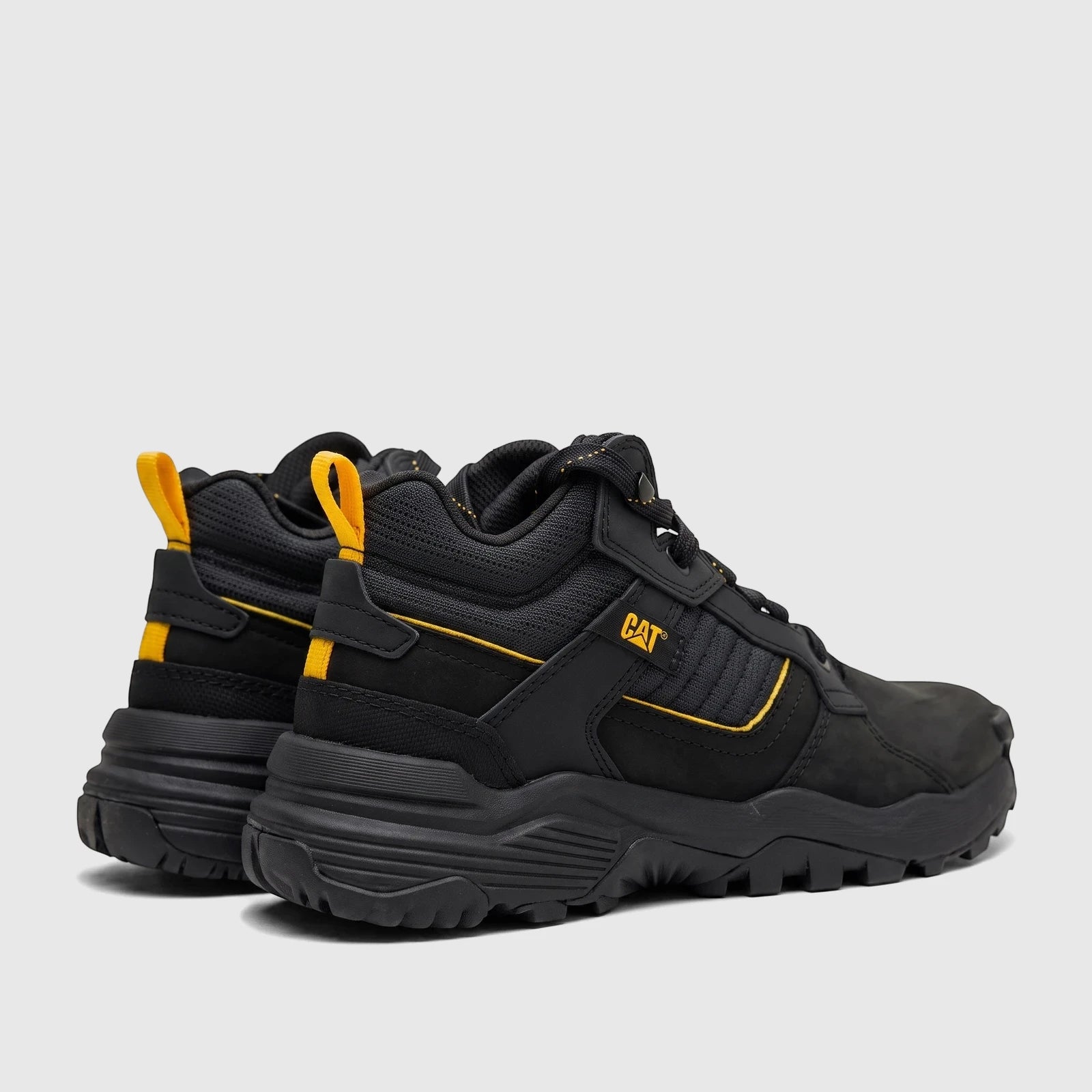 Cat Men's Grapple Leather Mid boots in black with yellow accents, shown from a rear-side view, highlighting the rugged