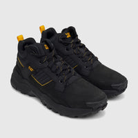 Pair of black Cat Men's Grapple Leather Mid P726961 work boots with yellow laces and accents, angled view.