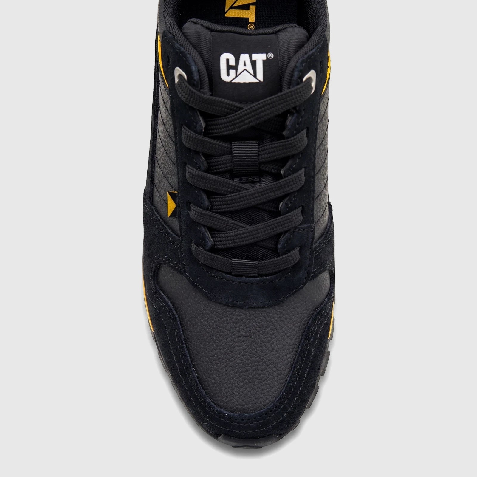 Close-up top view of a black Cat Men's Trigen P726923 CT401 sneaker with yellow accents and black laces.