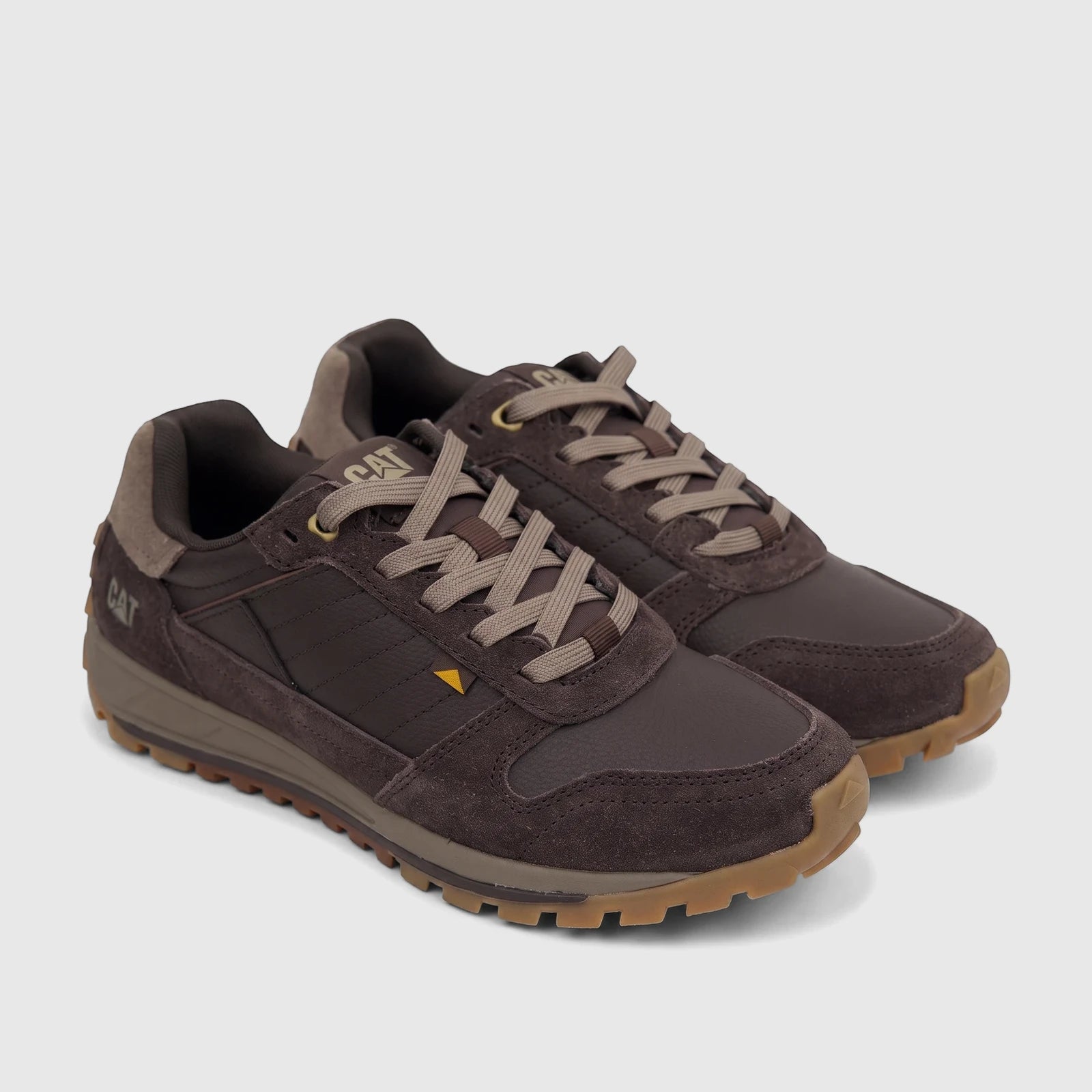 A pair of Cat Men's Trigen P726924 Coffee Bean CT402 sneakers, featuring dark brown uppers, light tan laces, and a rugged