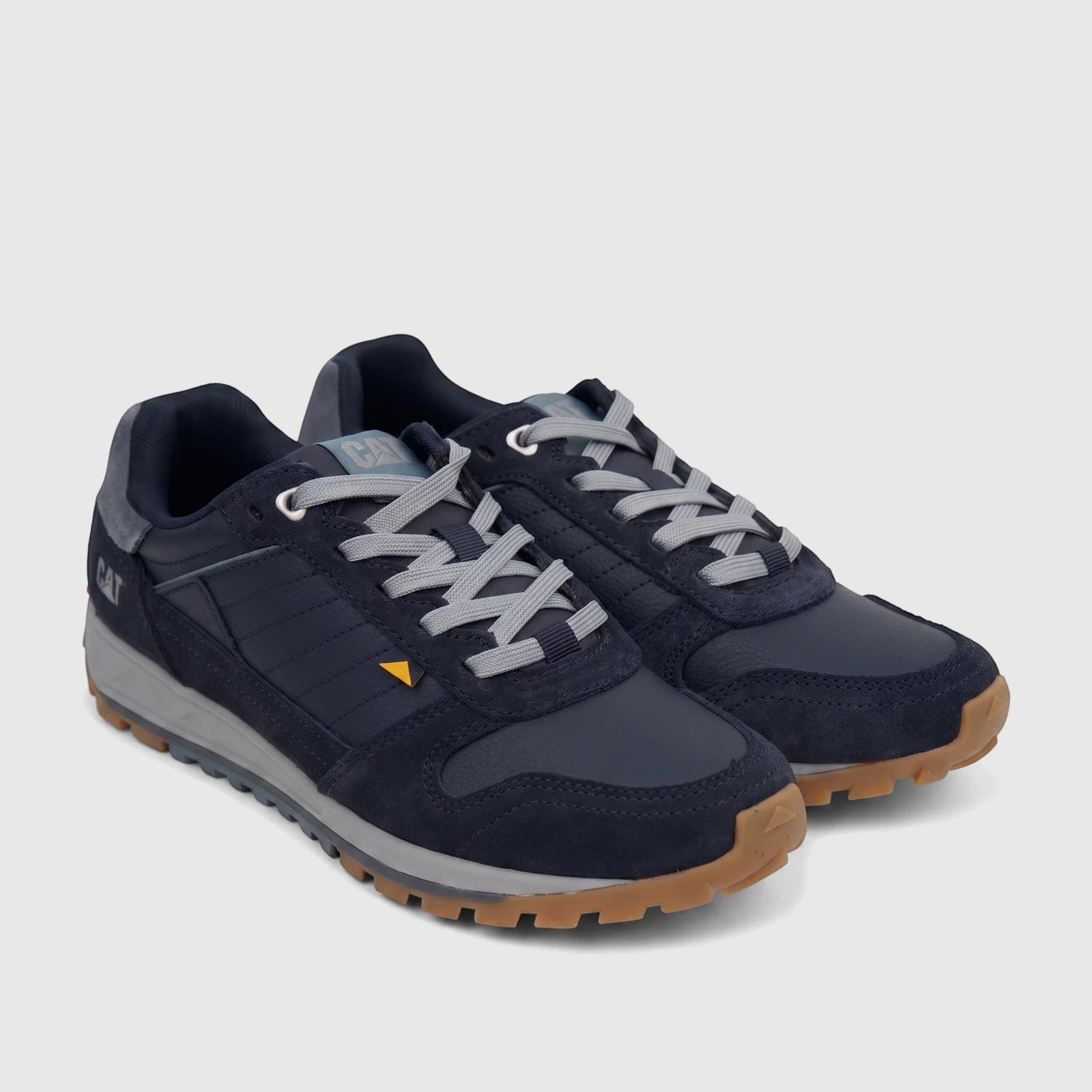A pair of navy blue Cat Men's Trigen P726925 Total Eclipse CT403 casual sneakers with grey laces, shown from a side angle.