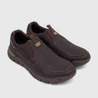 Cat Men's Versage Slip On shoes in coffee bean brown, featuring a textured sole, elastic side panels, and CAT branding.