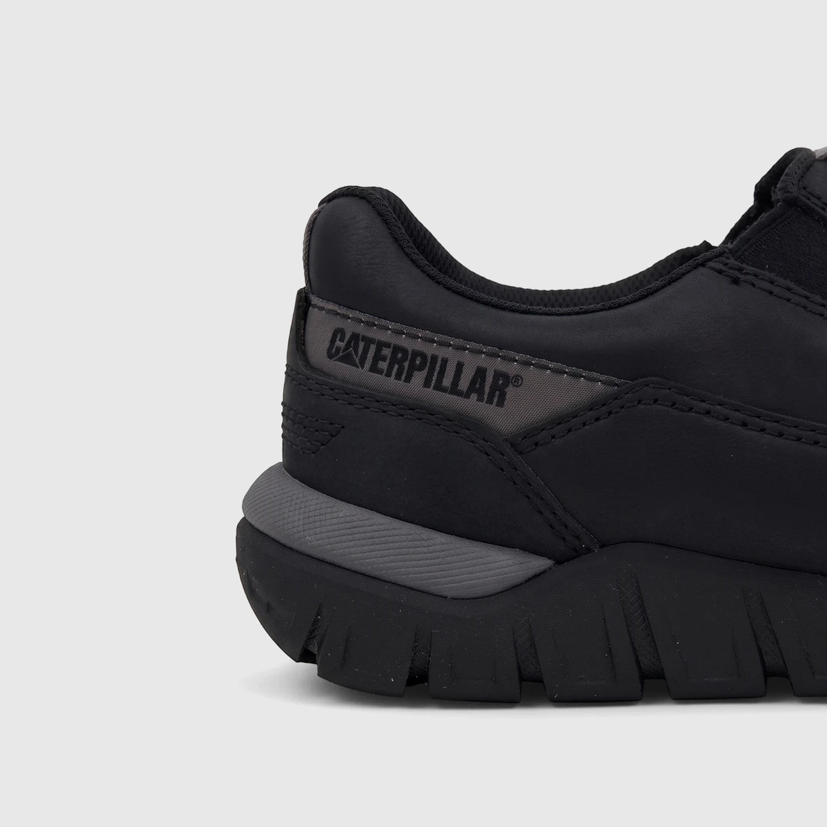 Cat Men's Versage Slip On P727014 shoe in black, featuring a visible Caterpillar logo on the side and a textured sole.