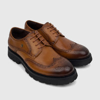 A pair of Crockett And Jones men's brown leather chunky sole lace-up brogue shoes, shown slightly angled on a white