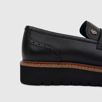 Close-up of a black pebbled leather Crockett And Jones men's chunky sole loafer with brogue details.