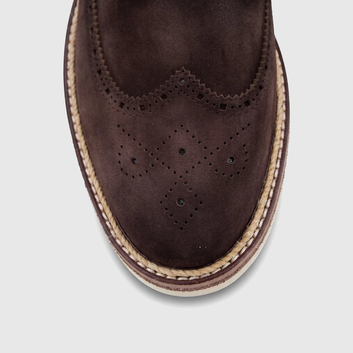 Close-up top-down view of a men's brown suede brogue shoe with perforated details and a braided espadrille sole.
