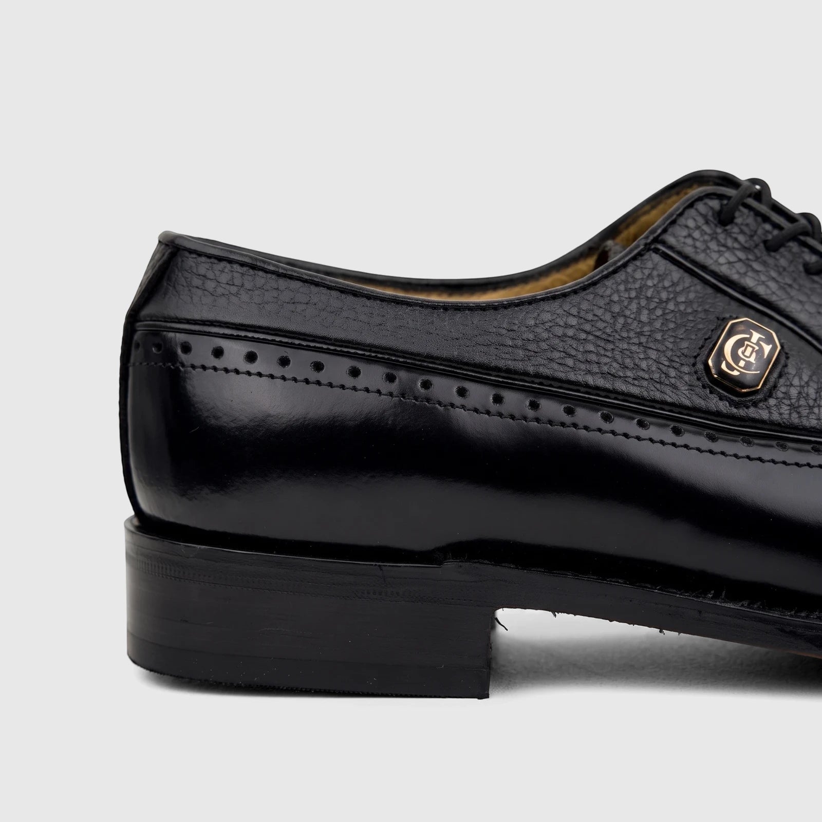 Close-up of a black leather Crockett and Jones Men's Dress Lace Up Jason shoe, showing the side, heel, and brogue details.