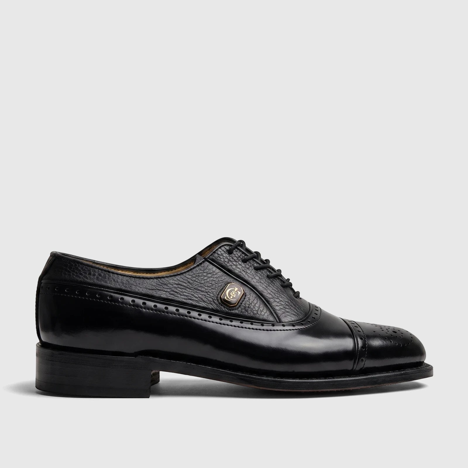 Black leather Crockett and Jones Men's Dress Lace Up Jason shoe, side view, with brogue detailing and a gold emblem.