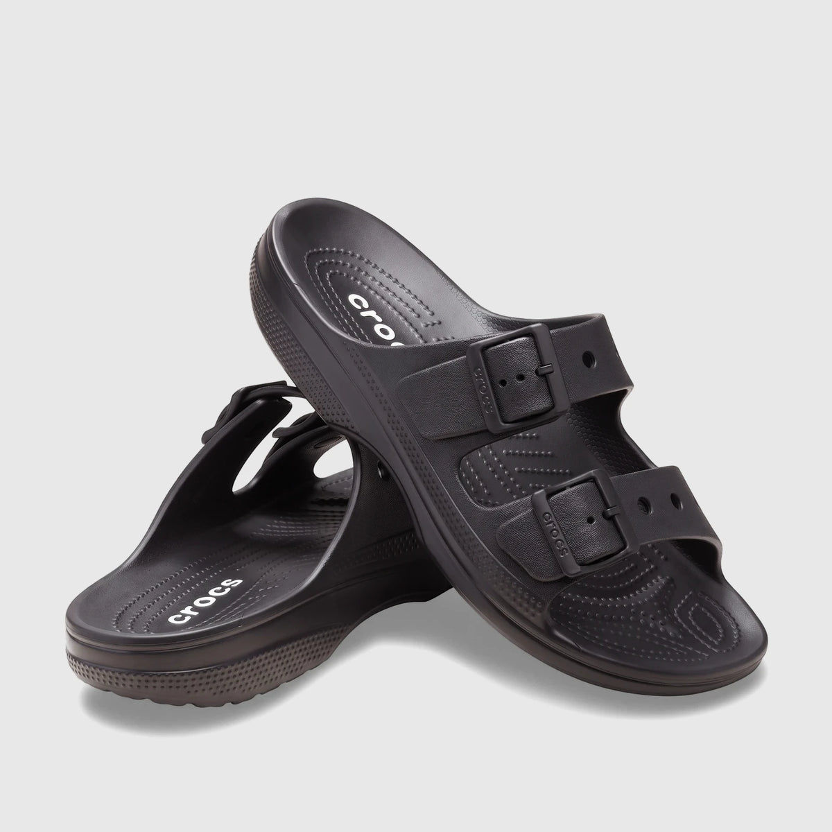 A pair of black Crocs Saturday Sandals, featuring two adjustable straps with buckles, shown from a slightly elevated view on