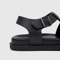 Close-up view of a black Fabino men's leather comfort sandal with a prominent chunky sole and metal buckle.