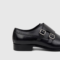 Black men's Fabino dress leather double monk strap shoe, visible from the side, showcasing its silver buckles and brogue