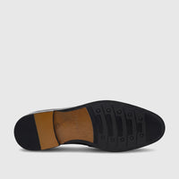 Fabino Men's black leather dress shoe sole, showcasing the textured rubber outsole and brown heel from a bottom view.