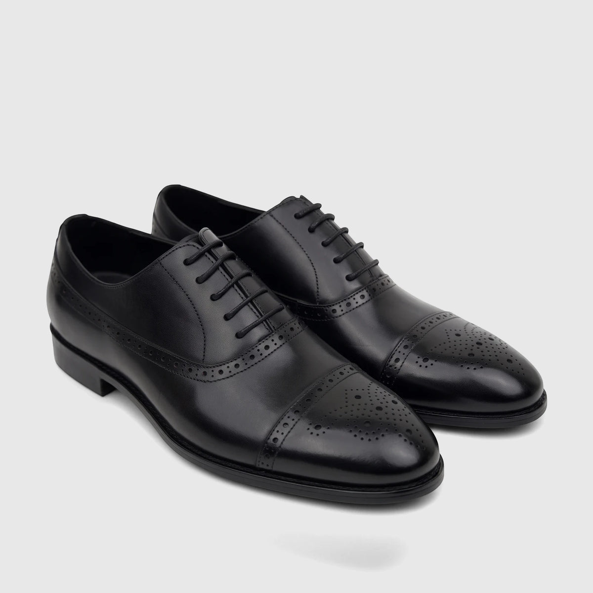 Black leather men's lace-up dress shoes with classic brogue and cap toe detailing, perfect for formal wear.