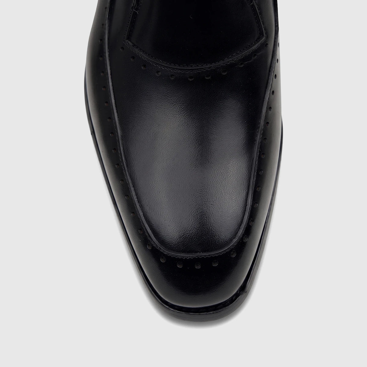 Close-up view of a black Fabino Men's leather slip-on dress shoe, featuring fine stitching and subtle perforations on the