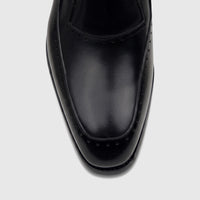 Close-up view of a black Fabino Men's leather slip-on dress shoe, featuring fine stitching and subtle perforations on the