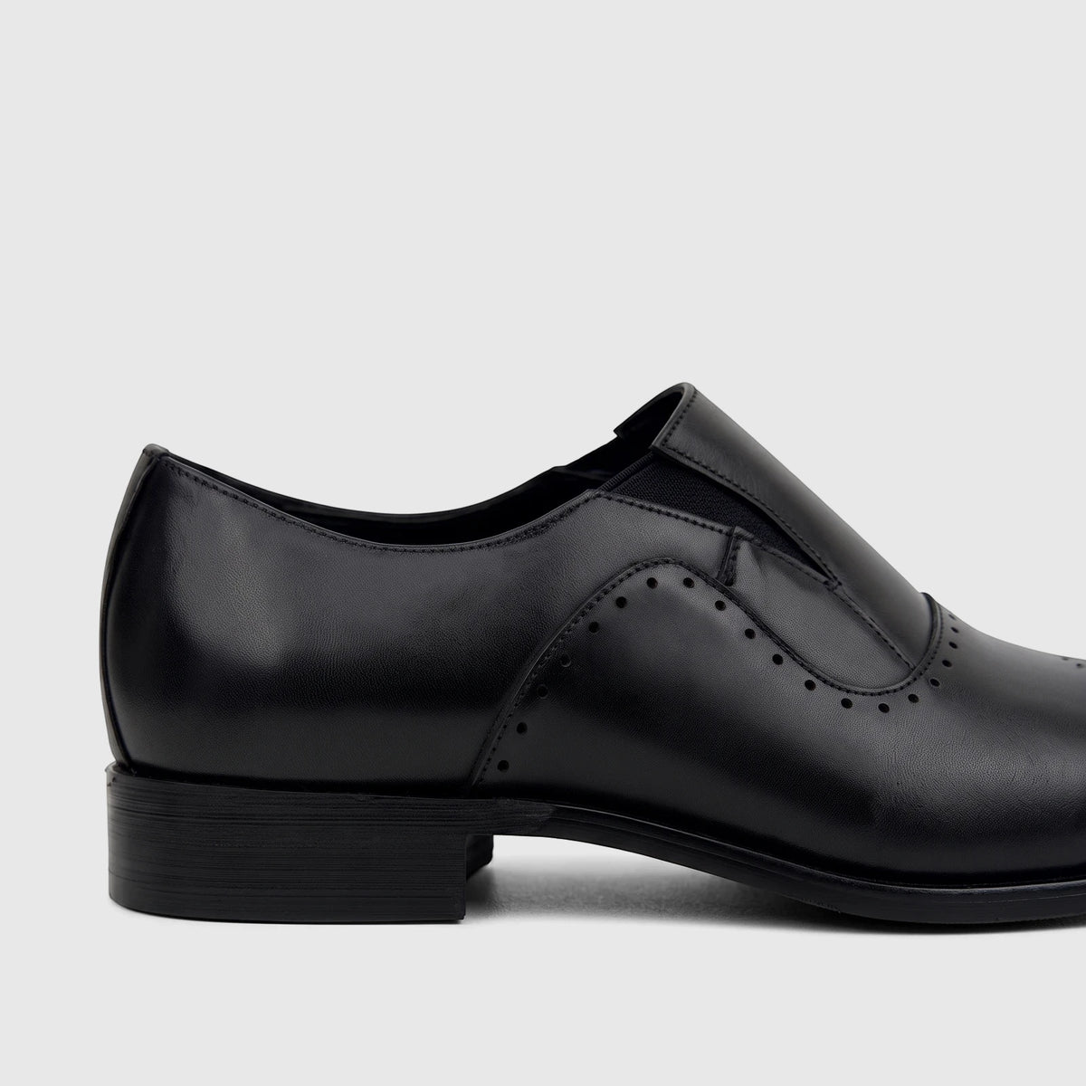Black leather slip-on dress shoe for men, showcasing the side profile with perforated details and a stacked heel.