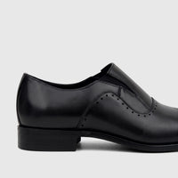 Black leather slip-on dress shoe for men, showcasing the side profile with perforated details and a stacked heel.