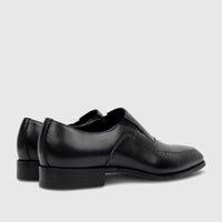 Pair of black leather men's slip-on dress shoes, showcasing a sleek design with perforated details and low heels from a side
