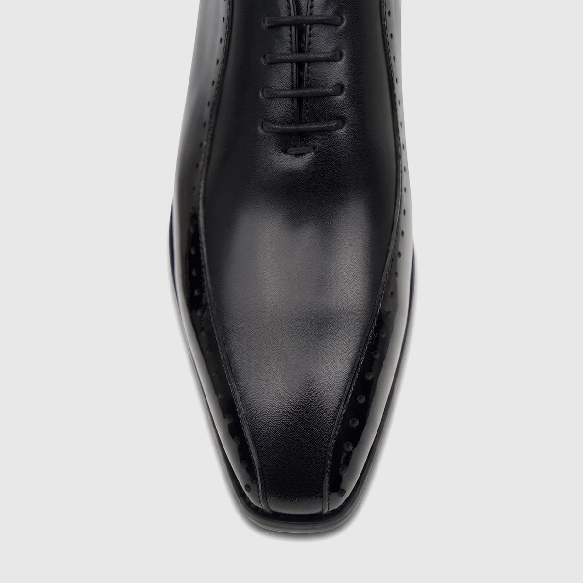 Close-up top view of a Fabino Men's black patent leather lace-up dress shoe, highlighting the glossy finish and brogue