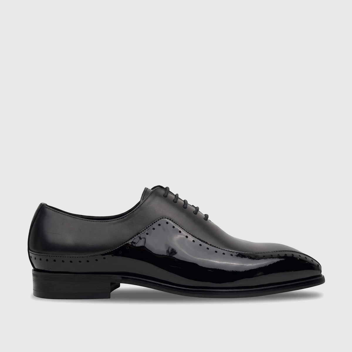 Men's black patent leather lace-up Oxford dress shoe with brogue details and a low block heel, side view.