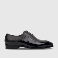 Men's black patent leather lace-up Oxford dress shoe with brogue details and a low block heel, side view.