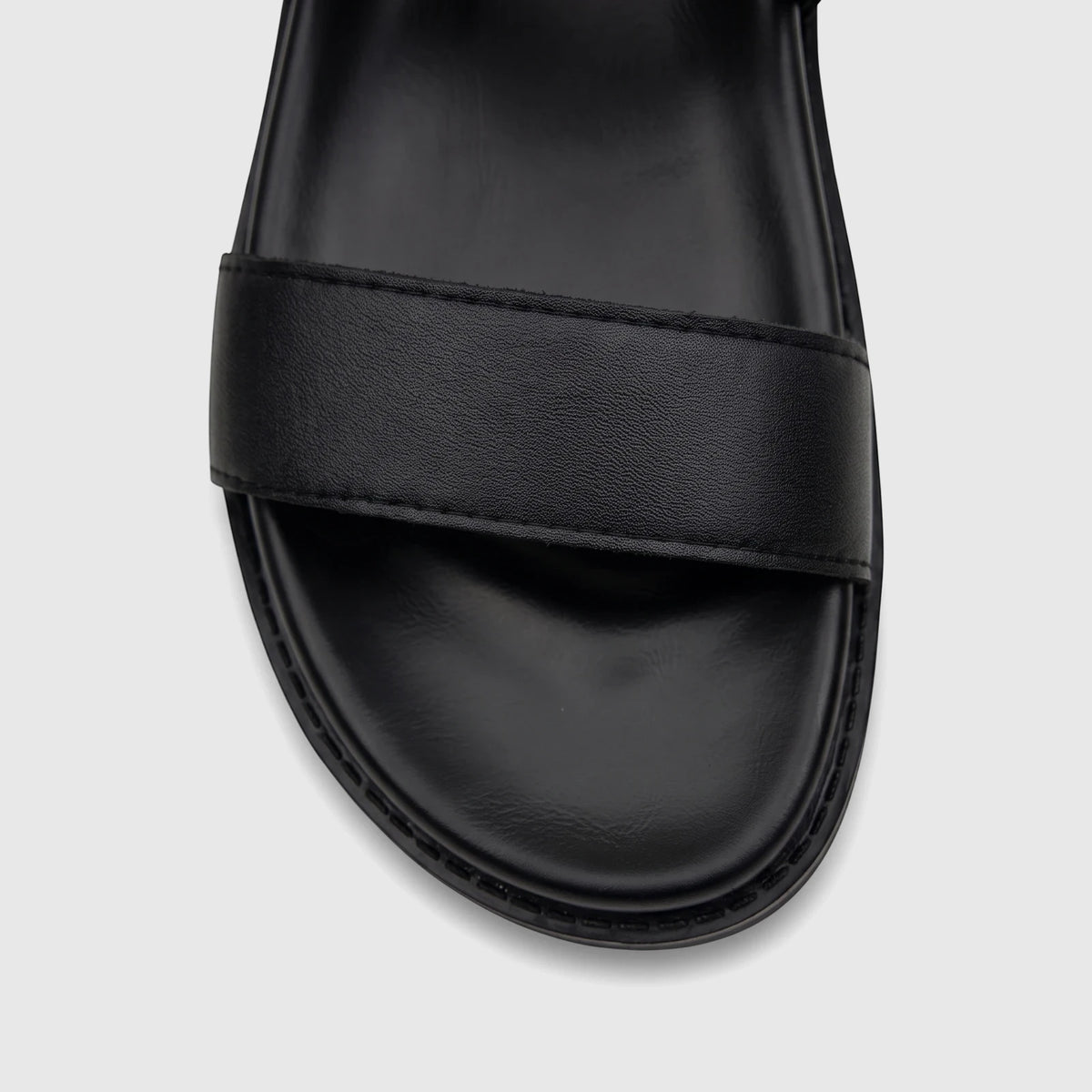 Close-up of a black Fabino men's leather comfort sandal, showcasing the textured strap and smooth footbed.