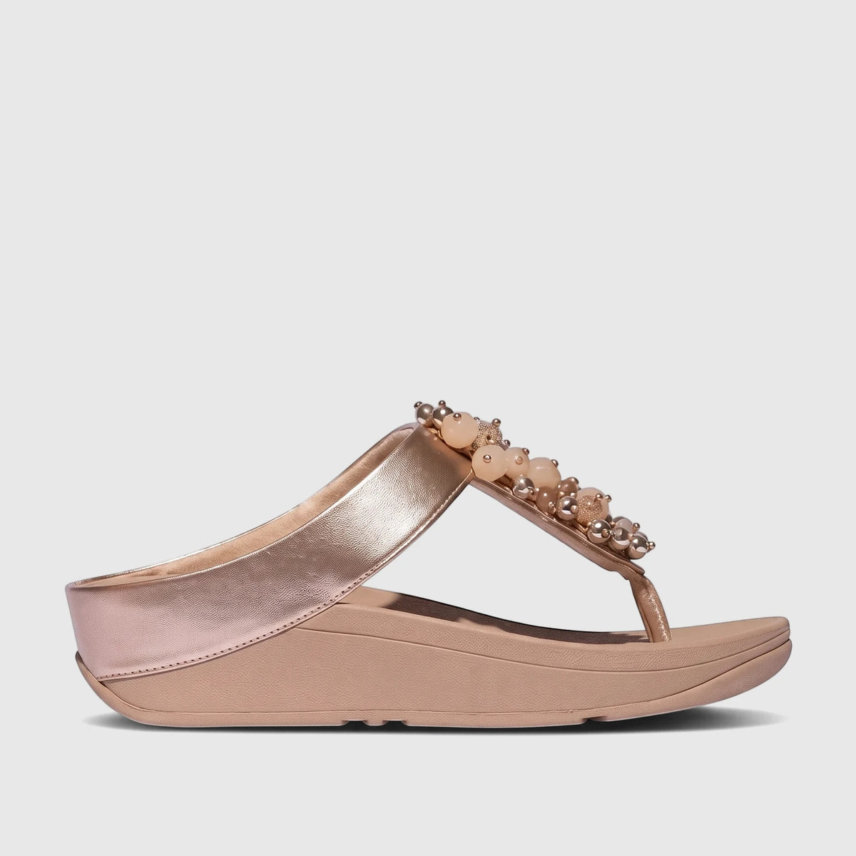 Fit Flop Fino Bauble Bead Comfort Sandal for ladies in classic beige and rose gold with a wedge heel, side view.