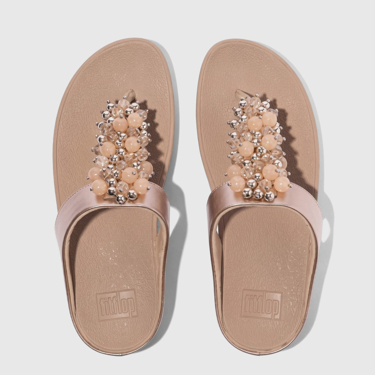 Pair of women's Fit Flop Fino Bauble Bead sandals in classic beige with decorative pink and silver bead embellishments,