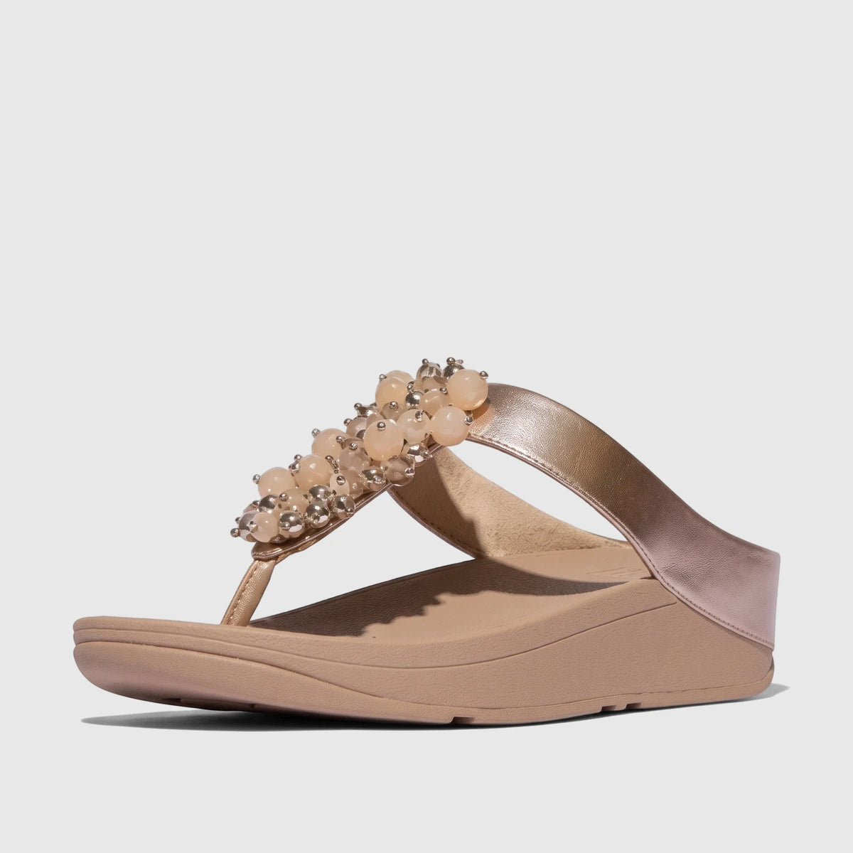 Classic beige Fit Flop Ladies Comfort Sandal with metallic rose gold strap and bauble bead embellishments, side view.