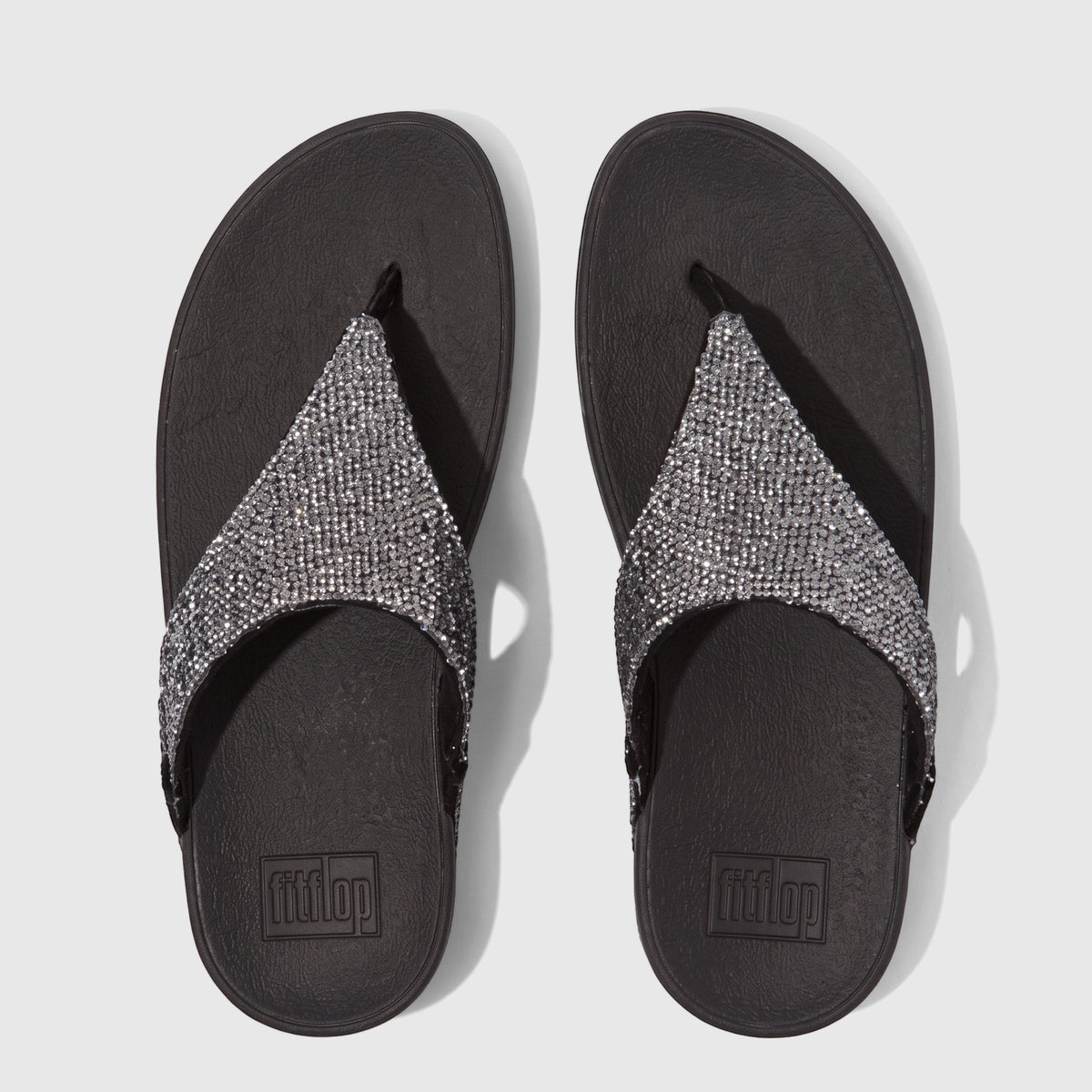 Pair of Fit Flop Ladies Comfort Sandals, Lulu Glitterball style, featuring silver glitter straps and black ergonomic soles,