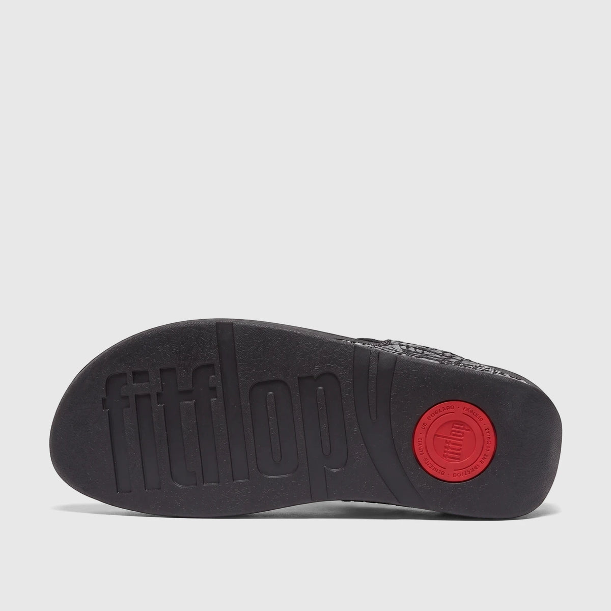 Underside view of a black Fit Flop Ladies Comfort Sandal Lulu Glitterball sole, featuring its textured surface and a red