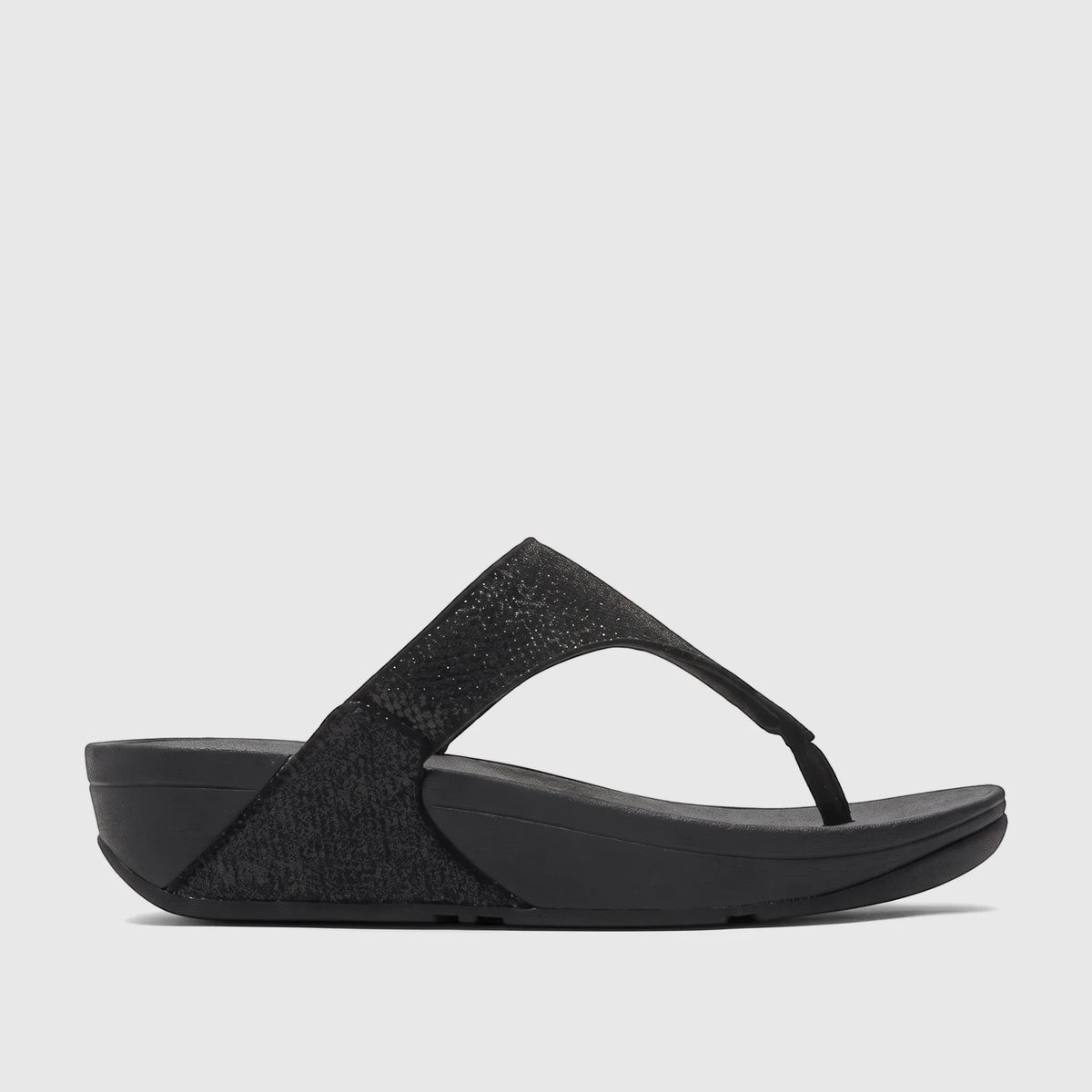 Side profile of a black Fit Flop Ladies Comfort Sandal Lulu Shimmerglitz, featuring a shimmering thong strap and a comfort